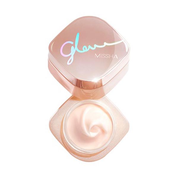 Open rose gold jar of multi-function glowing skin balm with smooth creamy texture on white background