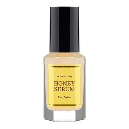 Clear glass bottle of honey serum with a yellow label and black cap, designed to boost skin elasticity