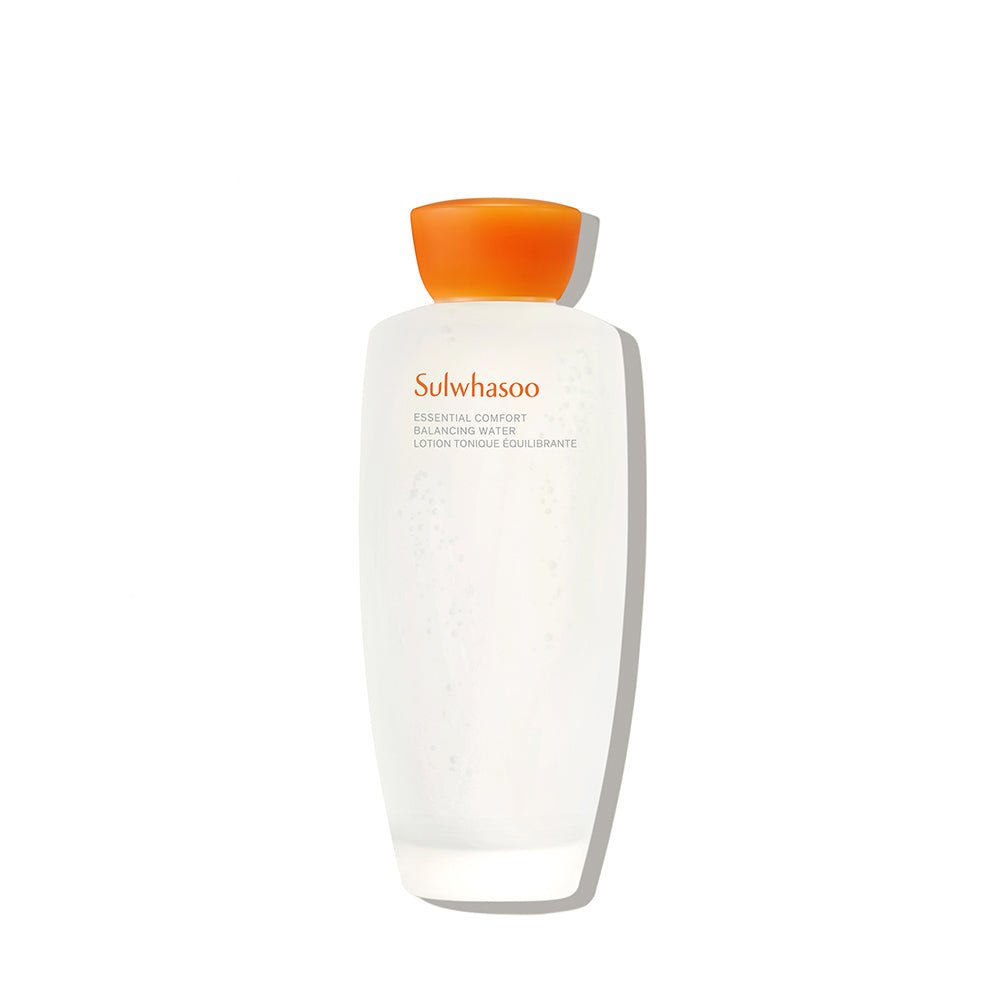 Frosted glass bottle of hydrating balancing water with matte white finish and bright orange cap on white background
