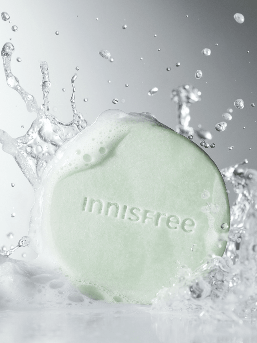 Light green shampoo bar embossed with brand name surrounded by water splash and foam droplets for scalp refreshment