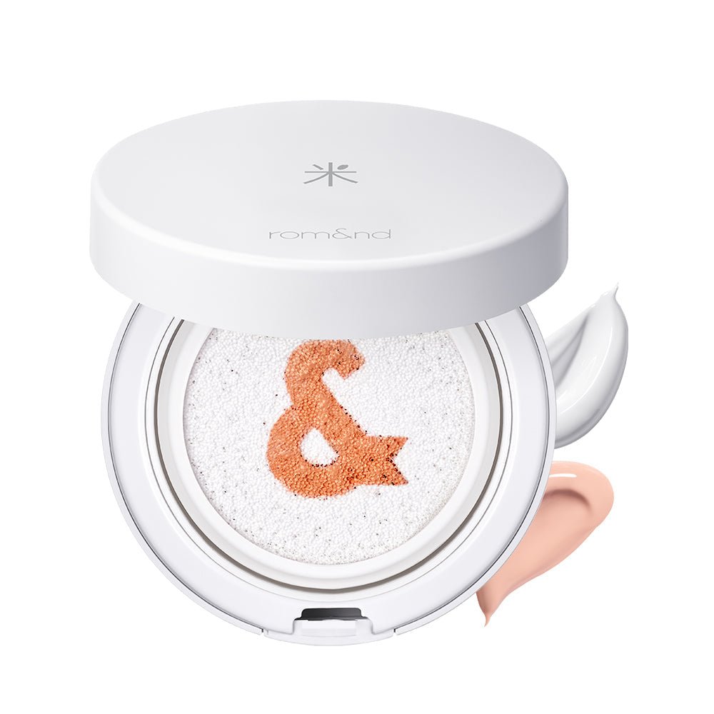 White cushion compact with an orange ampersand detail and two creamy swatches highlighting tone-up sun protection benefits