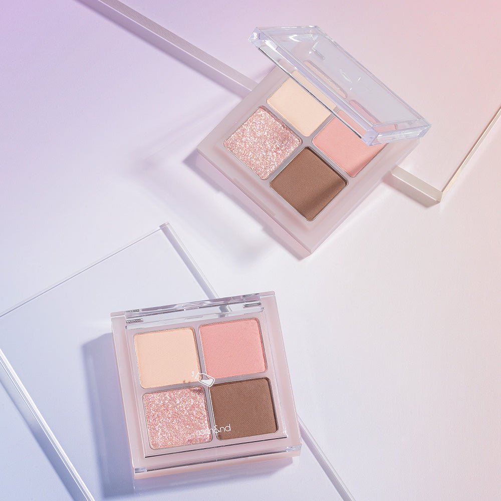 Two open eyeshadow compacts with four shades each including matte peach, shimmer pink, and brown tones on pastel background