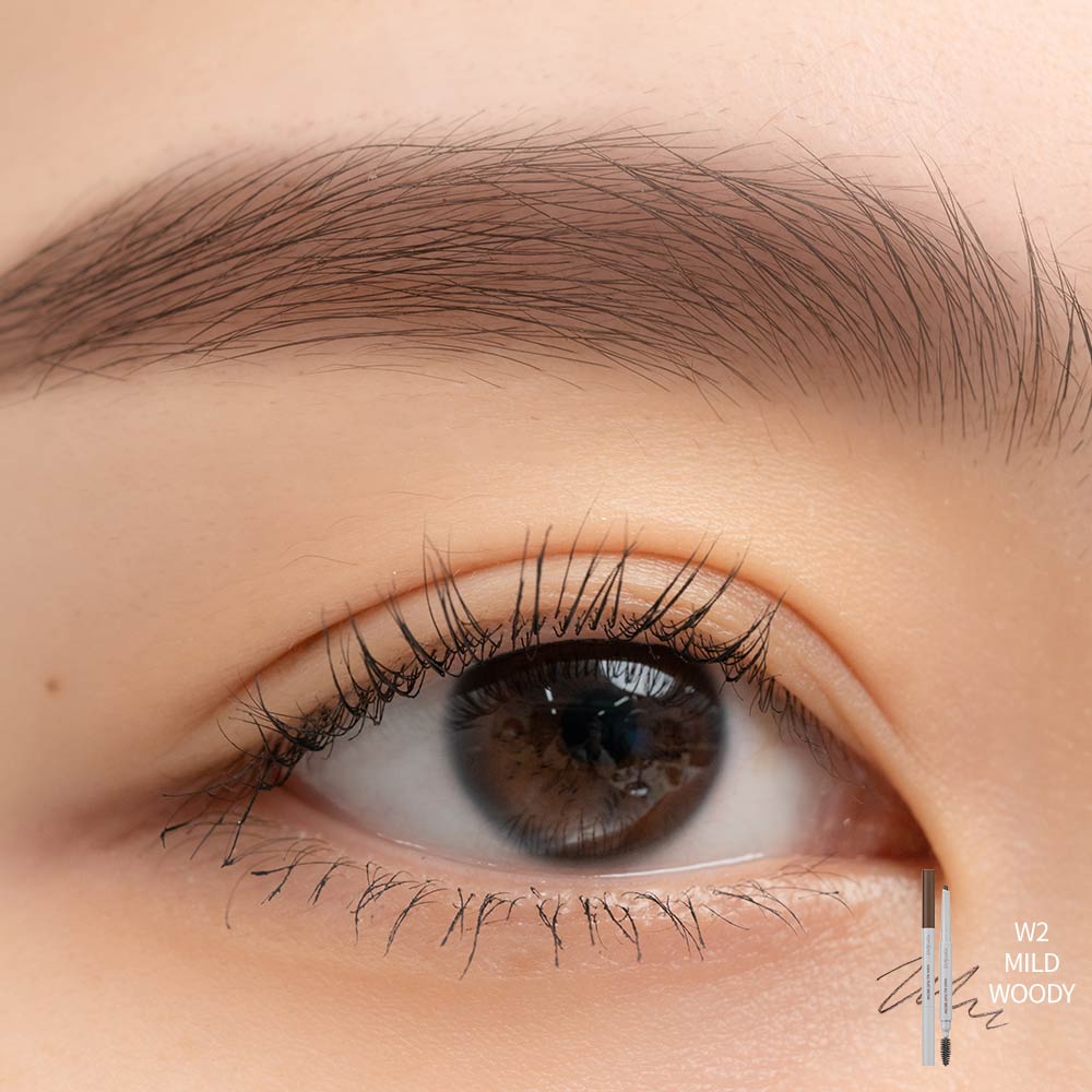 Close-up of brown eye with natural, softly defined eyebrow using flat brow product labeled W2 Mild Woody