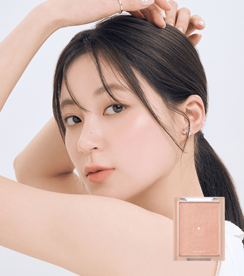 Close-up of woman with natural radiant skin glow, showcasing subtle peach-toned highlighter compact nearby.