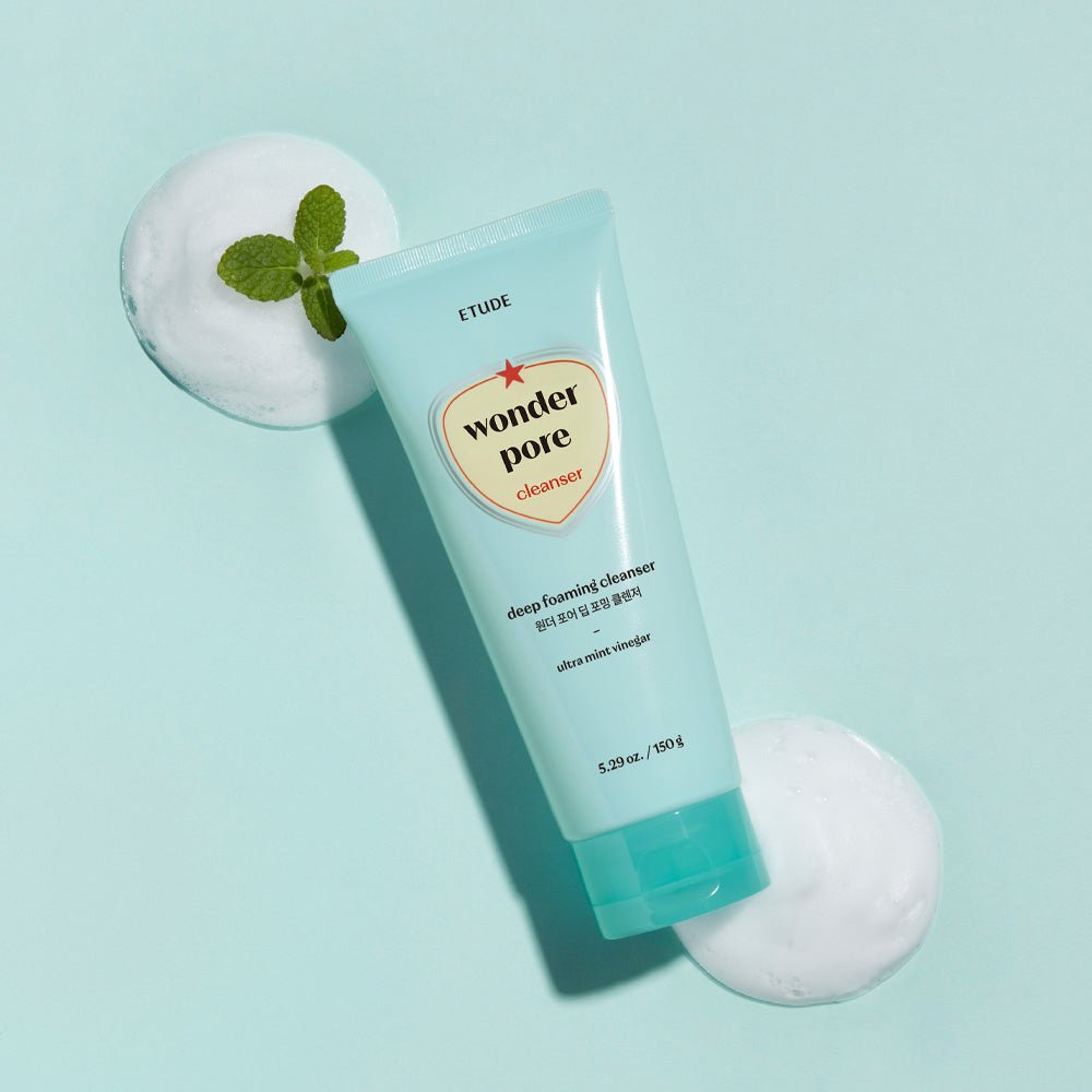 ETUDE Wonder Pore Deep Foaming Cleanser 150g in blue tube with white foam and fresh green mint leaf on light blue background