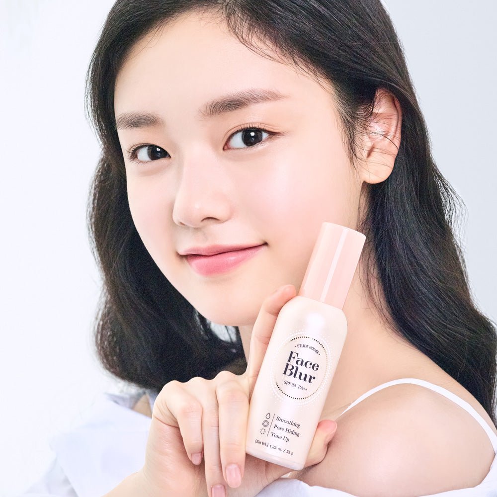Young woman with smooth skin holding ETUDE Face Blur SPF 33 PA++ 35g bottle for flawless finish look