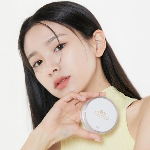 Young woman with flawless skin holding VT Cica Skin Fit Cover Cushion - 3 Colors 12g SPF50+/PA++++ in white compact case