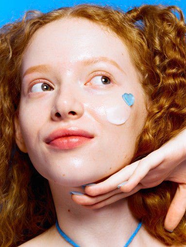 Young woman with fair skin and red curly hair applying Dr.Jart+ Vital Hydra Solution Hydro Plump Overnight Face Mask 75ml on cheek
