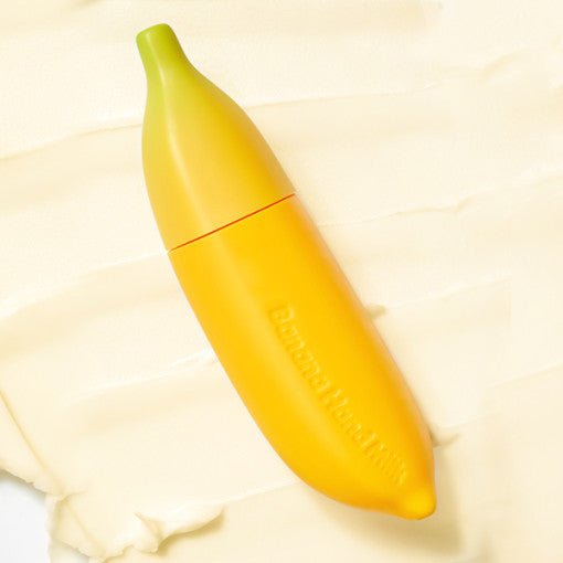 Yellow banana-shaped tube of hand moisturizer lying on creamy textured surface highlighting deep hydration benefits