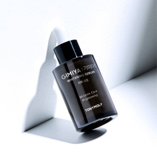 Black dropper bottle of whitening serum highlighting melanin care and brightening benefits on white surface