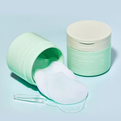 Mint green jars of soothing pore care pads with clear liquid and small transparent spatula on light blue surface