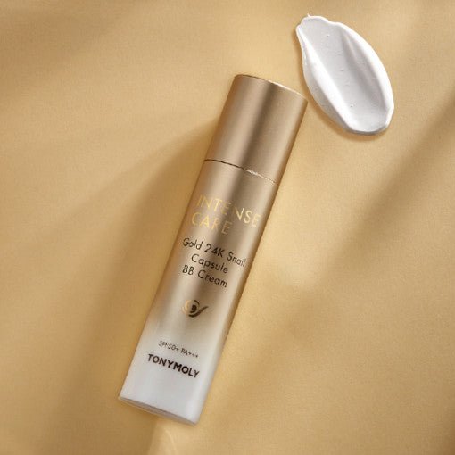 Gold and white bottle of nourishing BB cream with smooth cream swatch on warm beige background