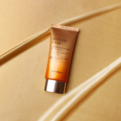 Orange gradient tube of gold 24K snail sun cream with silver cap emphasizing moisturizing and high SPF protection benefits