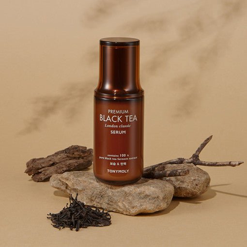 Brown matte serum bottle with clean white text, displayed on natural stones and dried tea leaves background