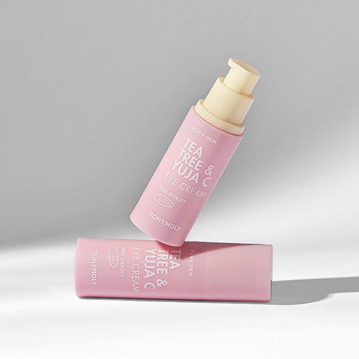 Two pink bottles of brightening eye cream with pump dispensers casting soft shadows on a light gray surface
