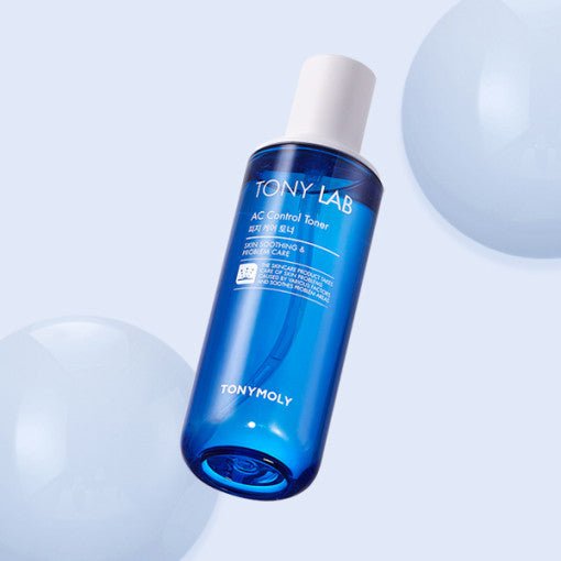 Blue translucent bottle of AC Control Toner with white cap shown against pale background with soft spheres nearby
