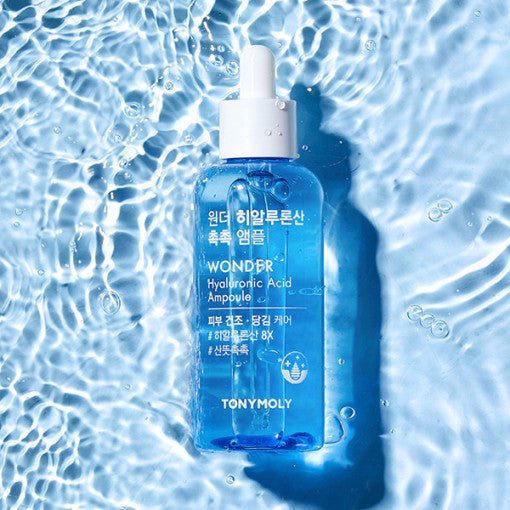 Blue dropper bottle of hydrating ampoule with clear liquid resting on rippling water surface