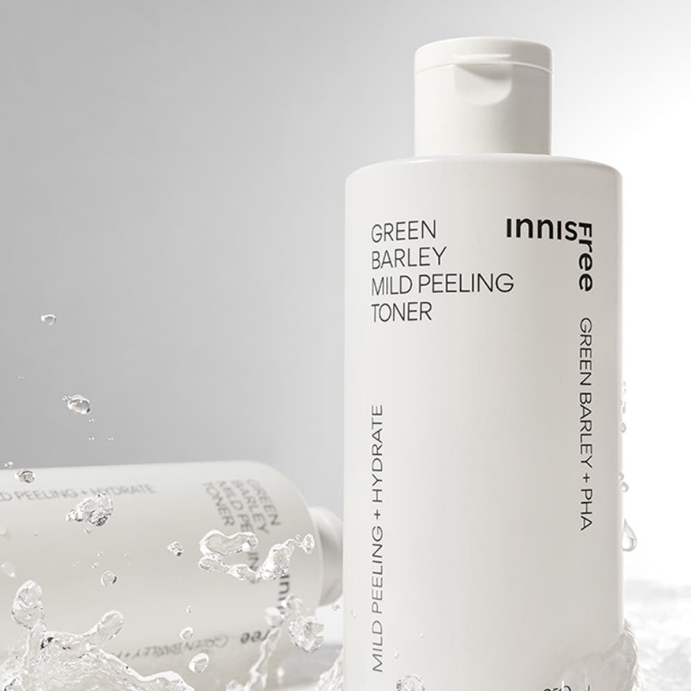Minimalist white toner bottle labeled mild peeling and hydrate with water splashes in soft lighting background