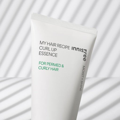 White tube of curl essence for permed and curly hair with subtle striped shadow pattern background
