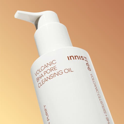 White pump bottle of pore cleansing oil with volcanic BHA formula on warm beige background