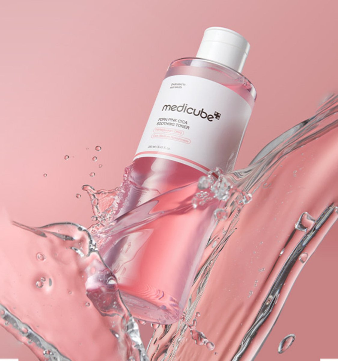 medicube PDRN Pink Cica Soothing Toner 250ml with brightening effect in pink bottle splashing clear water on pink background