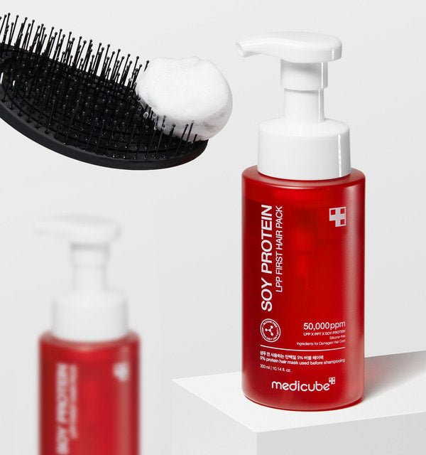 medicube Soy Protein Lpp First Hair Pack 300ml in red bottle with white pump next to hairbrush with foam for professional treatment