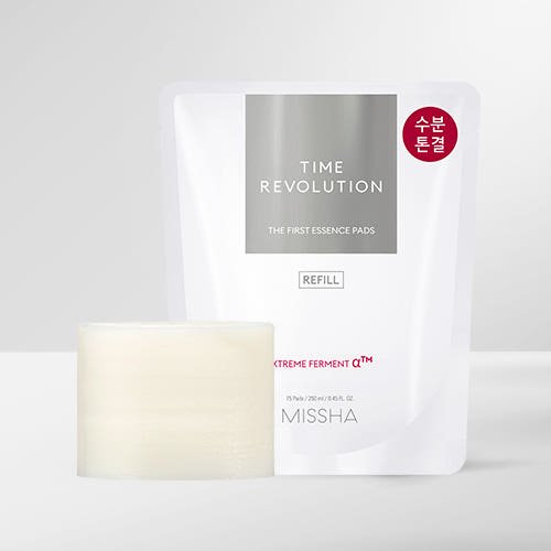 White refill pouch of Time Revolution essence pads with a neat stack of thin, soft cotton pads in front on gray background