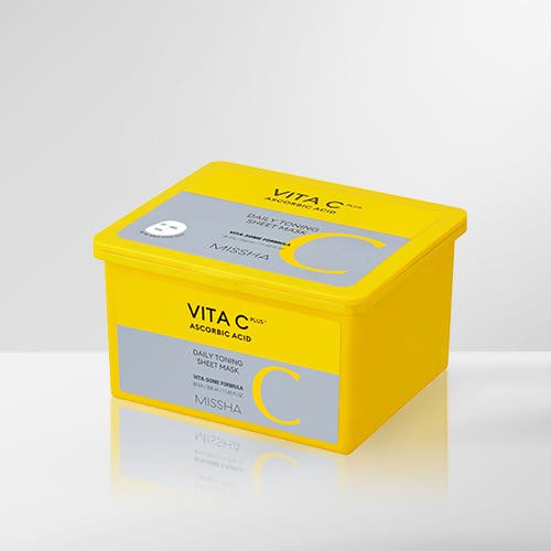 Bright yellow container of daily toning sheet masks featuring ascorbic acid for skin brightening benefits on white surface
