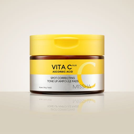 Amber jar with bright yellow lid of vitamin C ampoule pads for brightening and spot correction on soft beige background