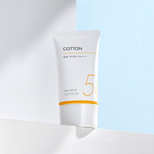White tube of high SPF50+ sun protection cream with minimalist text and orange accent on bright background
