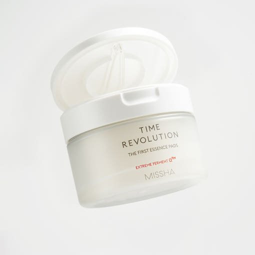 Frosted white jar of moisturizing essence pads with open lid and visible applicator on light background