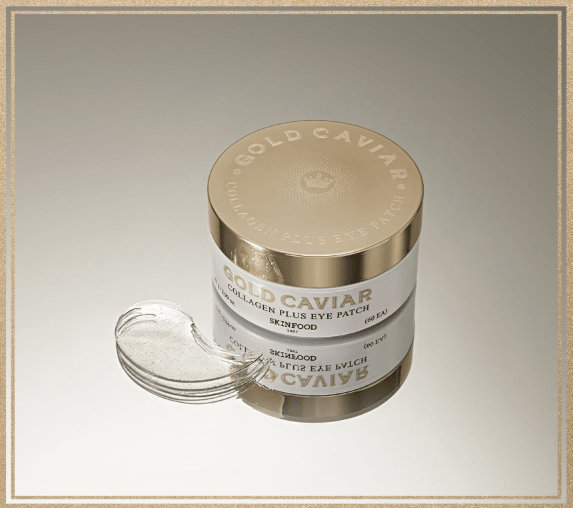 Gold-toned jar of collagen eye patches beside a single translucent patch on reflective surface with soft beige background