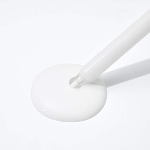 Close-up of smooth white sun protection ampoule liquid with dropper applicator on white surface