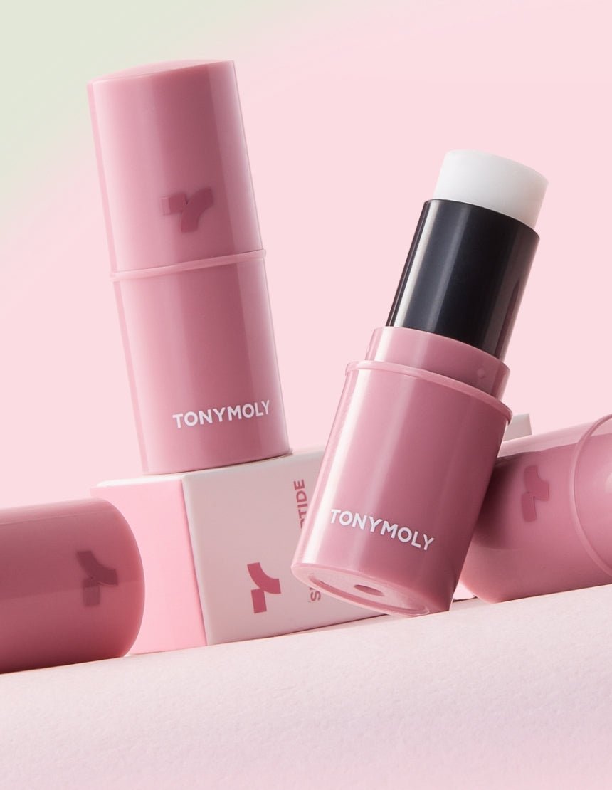 Pink moisturizing lip balm stick with white balm core and white brand lettering on soft pink background