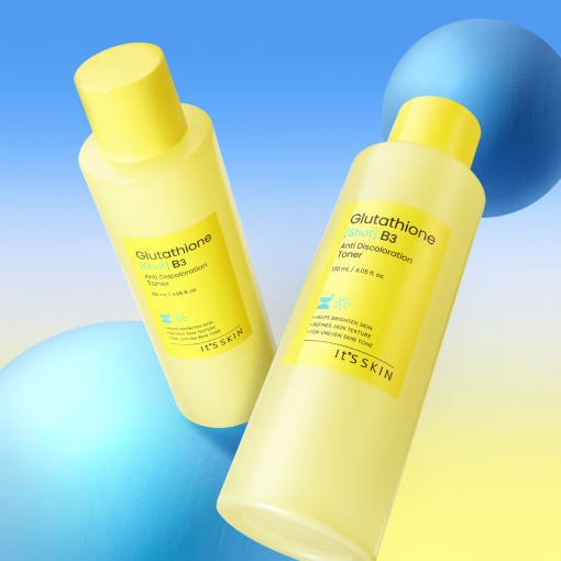 Two yellow plastic bottles of brightening anti discoloration toner with blue spherical props on gradient background
