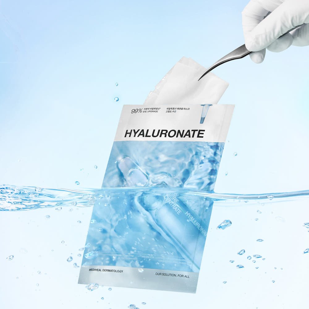 Water-themed packaging of a skincare mask with hyaluronate text and gloved hand lifting the sheet mask out