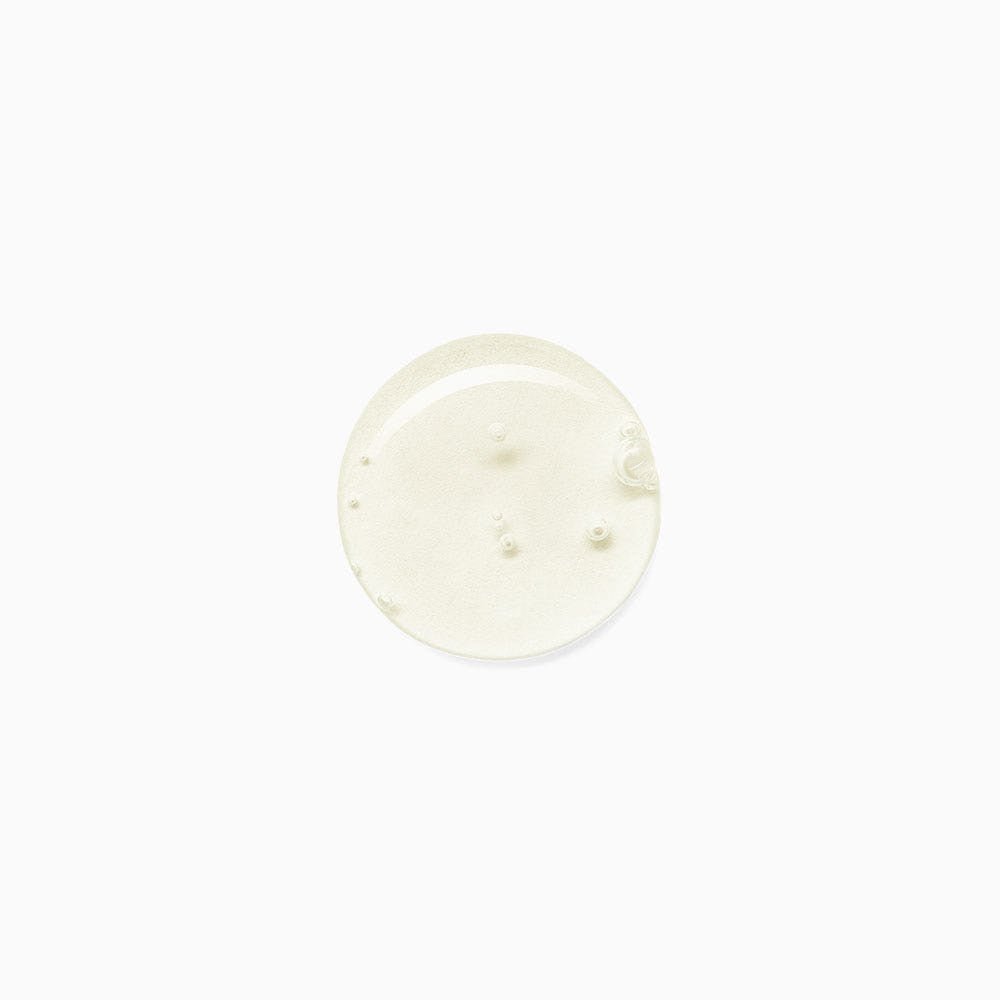 Clear drop of liquid shampoo with small bubbles suspended inside on a white background