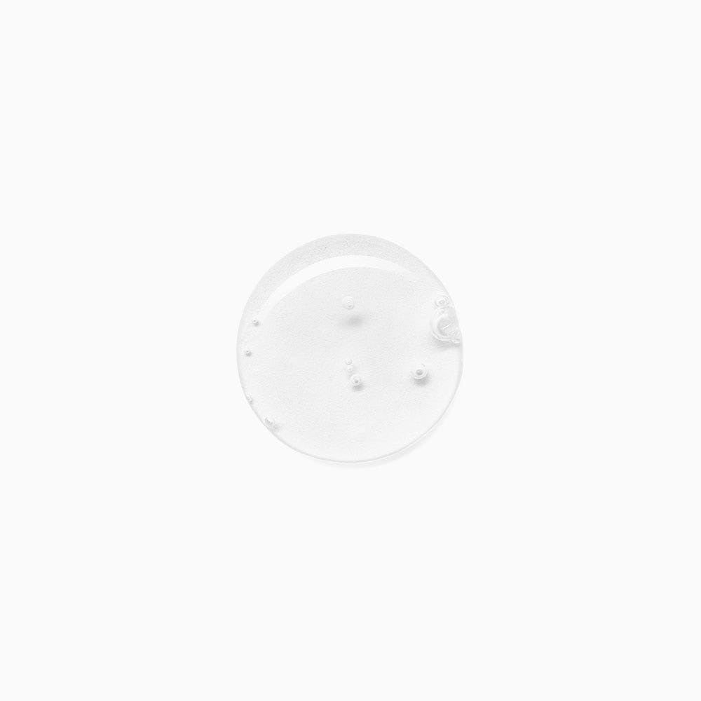 Clear, gel-like shampoo texture with tiny air bubbles suspended, shown on a white background.