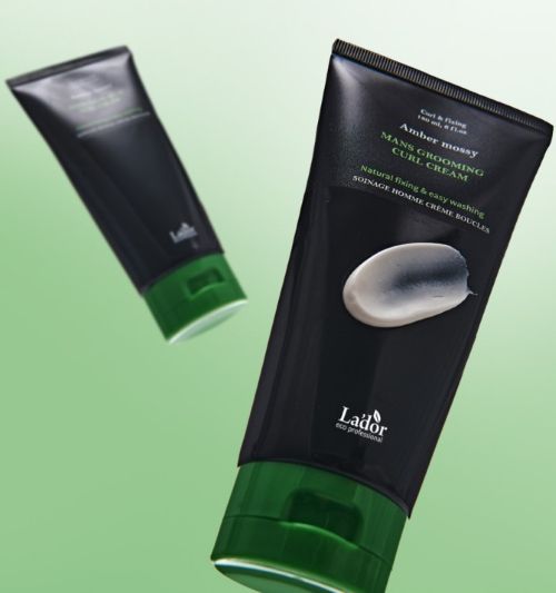 Black tube with green cap showing a smooth dollop of curl cream against a soft green gradient background