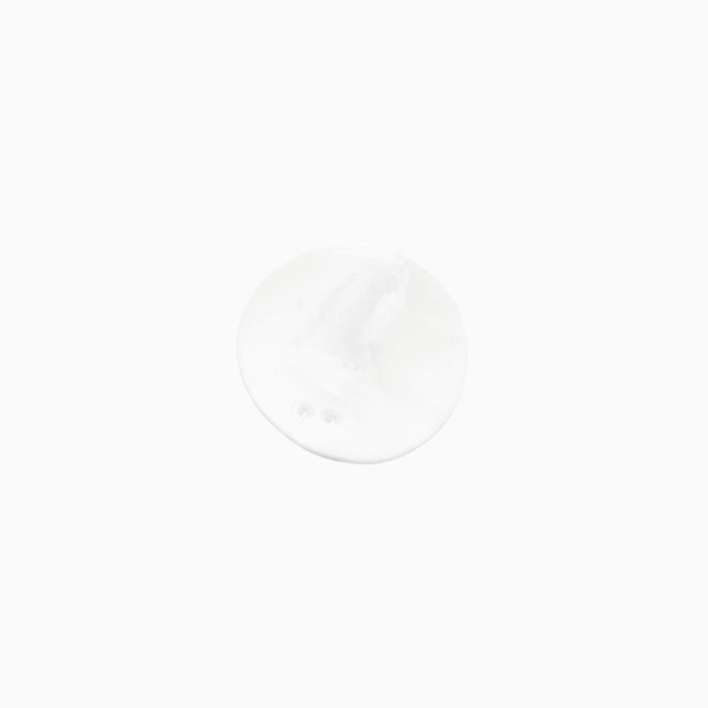 White foamy shampoo lather in a smooth round shape on a plain white background.