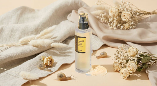 COSRX Snail 96 Mucin Power Essence bottle surrounded by dried flowers and soft fabric, highlighting its hydrating properties.