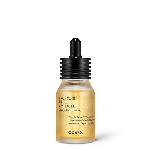 Small frosted glass dropper bottle with golden propolis ampoule and black ribbed cap on white background