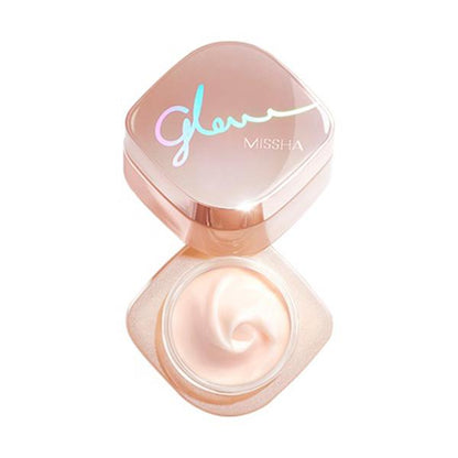 Open rose gold jar of multi-function glowing skin balm with smooth creamy texture on white background