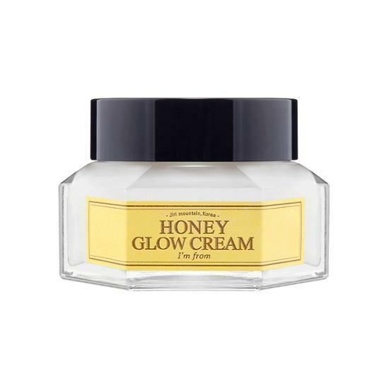 Clear jar of moisturizing honey glow cream with yellow label and black lid on white background