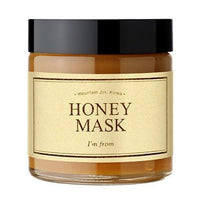 Glass jar of hydrating honey mask with beige label and black lid on white background