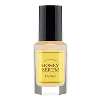 Clear glass bottle of honey-colored serum with black cap and yellow label highlighting elasticity boost benefits