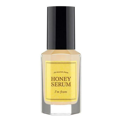 Clear glass bottle of honey-colored serum with black cap and yellow label highlighting elasticity boost benefits