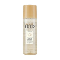 Clear bottle of moisturizing lip and eye makeup remover with gold cap and mango seed design on white background