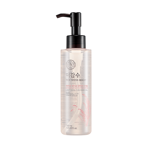 Clear pump bottle of gentle rice water bright cleansing oil with subtle pink grain illustration on white background