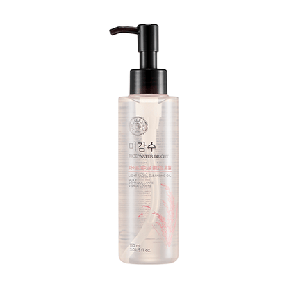 Clear pump bottle of gentle rice water bright cleansing oil with subtle pink grain illustration on white background